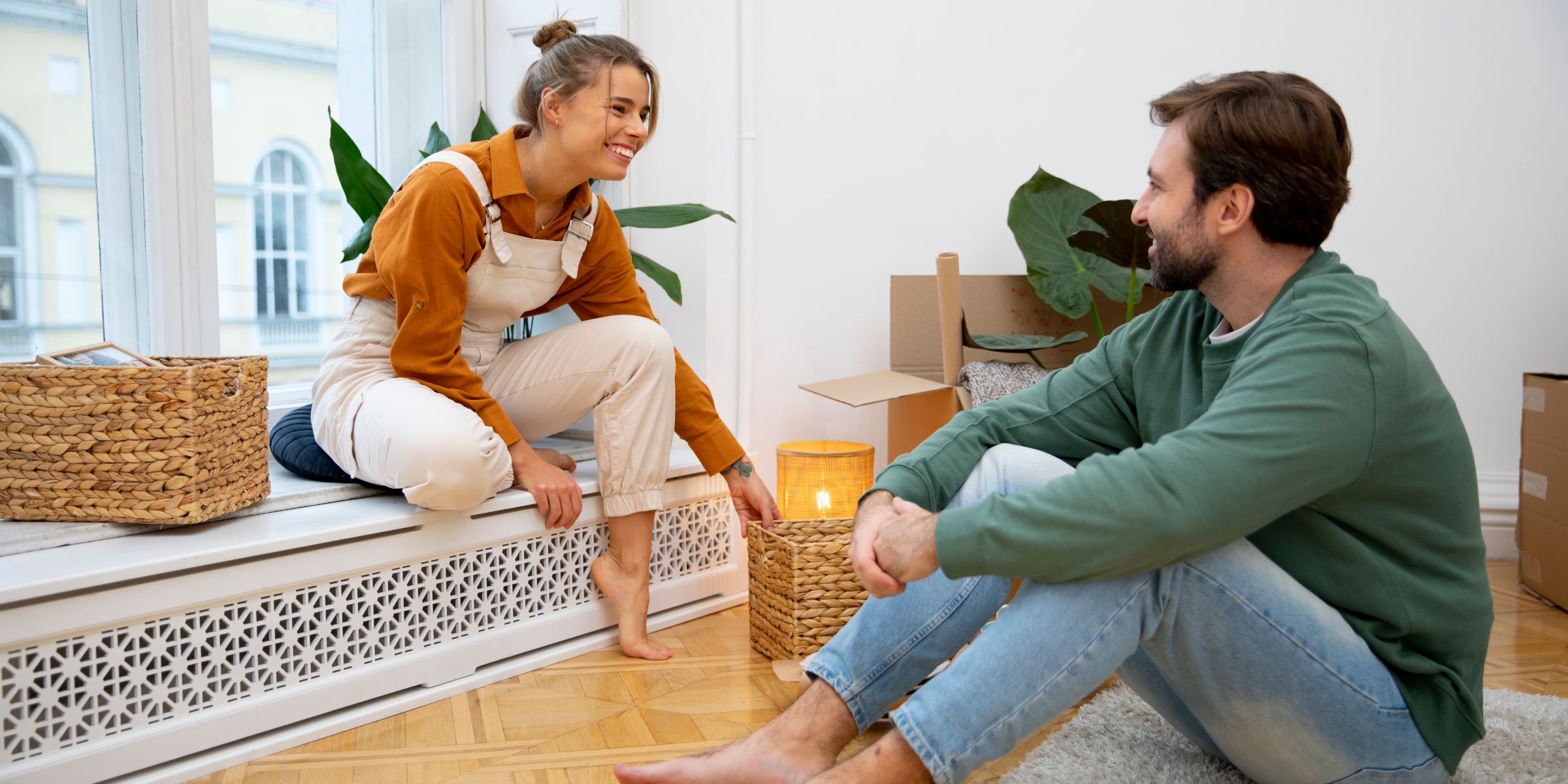 Paar sitzt in einer neuen Wohnung und bespricht gemeinsame Einrichtungsideen